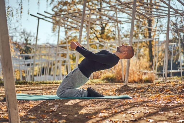 Personal Trainer macht ein Lean Back beim Outdoortraining.